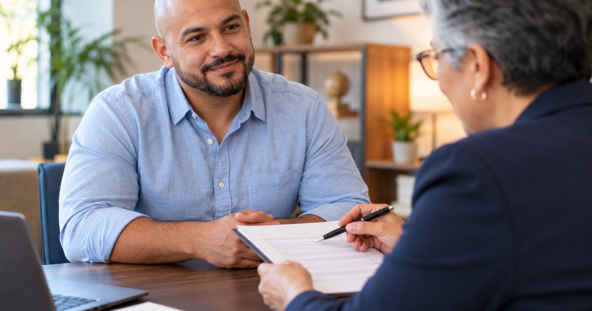 Loan advisor reviewing documents with a smiling customer at a desk